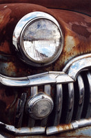 Color photograph of the chrome grill and rust of an antique DeSoto antique automobile