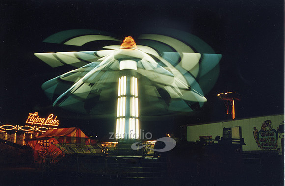 Color photograph of the Flying Bob carnival ride after dark in time lapse photography by Crystal Nederman