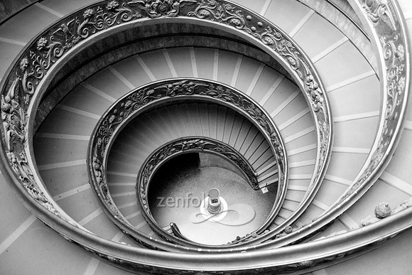 This is a black and white photograph of the ornate stairway at the Vatican Museum.