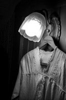 Color photograph of a soft glow of a vintage lamp on an antique nightgown by Crystal Nederman