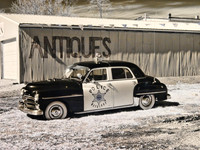 Black and White Infrared photograph of an old police car in front of an Antique building by Crystal Nederman.